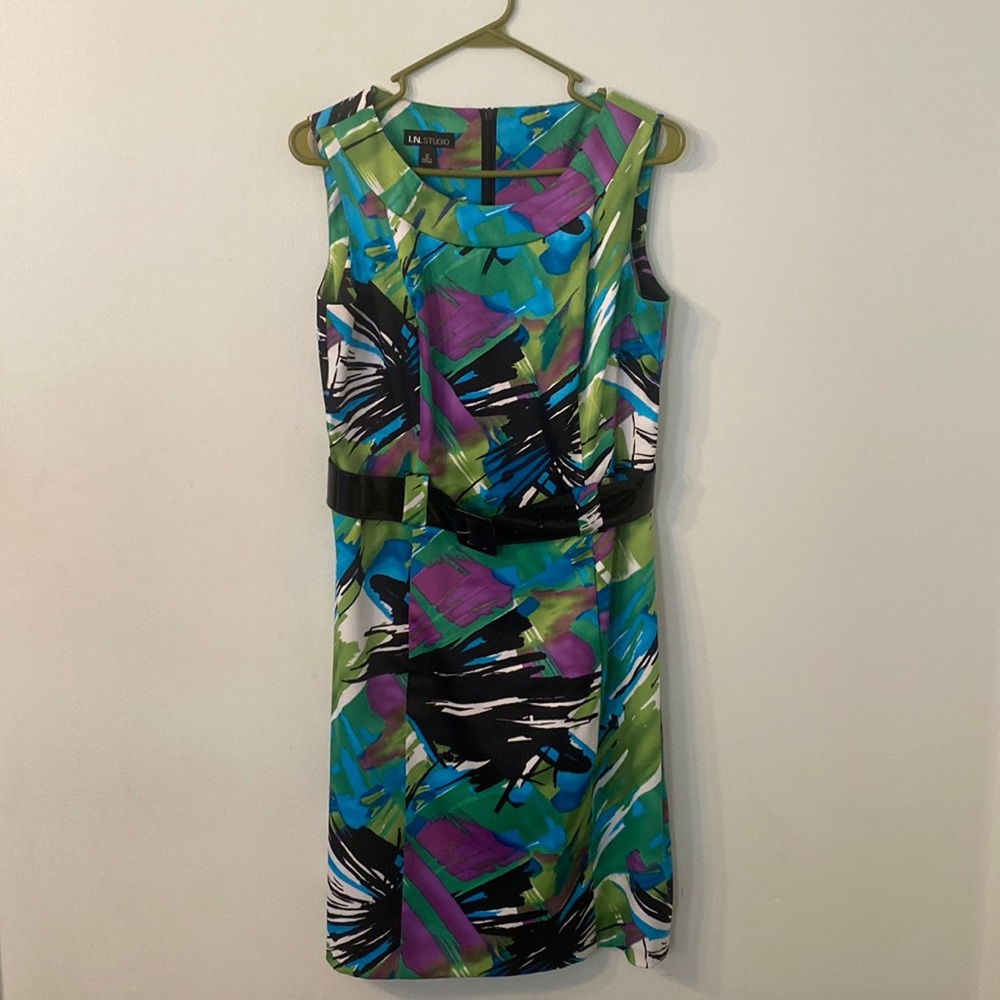 Sleeveless dress with patent leather belt and hidden back zipper.